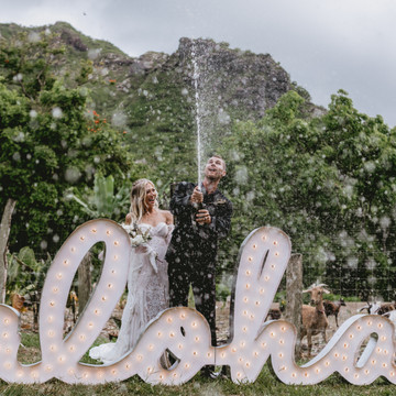 Abby + Nash spray champagne to celebrate with their furry goat friends. 
North Shore - Oahu. Hawaii!

Planner: @vidachicevents
Cake:@bakewithaloha
Rentals: @alohaartisans
Gown: @Magnoliawhite_hawaii
Hair and Makeup: @lovebylaur
Linens and table settings: @theweddinglinenco
Tap Truck: @alohataps 
Flowers: @vidachicevents 
Couple: @nashhagen + @abby_hawaii
Aloha marquee sign: @designed_with_aloha
Rings: @theweddingringshop